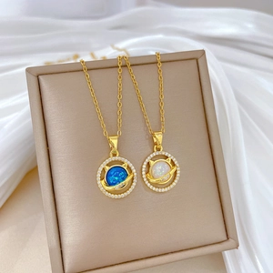 Detail of cat planet necklaces with blue and white stones on a silk backdrop
