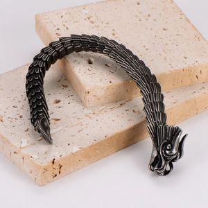 Macro shot of vintage black stainless steel bracelet with dragon scale texture and dragon head