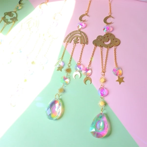 Detail of crystal suncatchers with golden moon and star charms reflecting rainbow light
