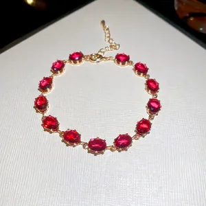 Elegant gold chain bracelet with oval red cubic zirconia stones and adjustable clasp