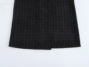 Gros plan sur la texture du tissu en tweed noir avec fils brillants et motifs tissés