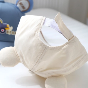Detail of adjustable velcro strap on kids beige cotton baseball cap with bear ears