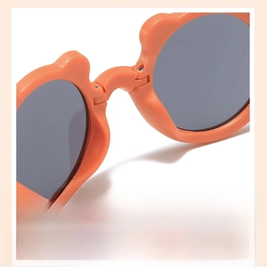 Vue rapprochée de lunettes de soleil orange pour enfants avec plaquettes de nez intégrées