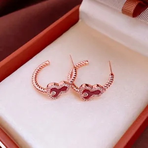 Rose gold twisted hoop earrings with a red heart-shaped pendant and white zircon stones