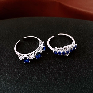 Gros plan sur des bagues argentées réglables avec pierres de zircon bleues et blanches