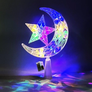 Glow of illuminated transparent plastic moon and star lamps on white base in dark setting