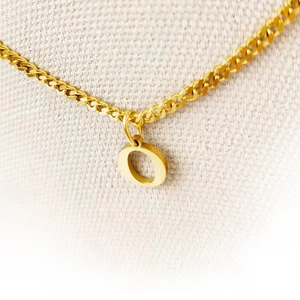 Detailed close-up view of a gold-plated stainless steel necklace with a letter O pendant