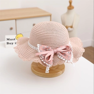 Detailed straw weave of kids pink sun hat with floral bow and delicate lace trim