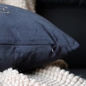Close-up of velvet cushion cover featuring gold embroidery and hidden zipper detail