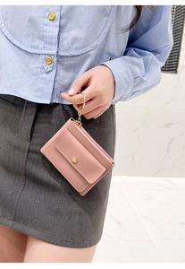 Detail view of a pink leather mini wallet featuring a premium golden keychain holder