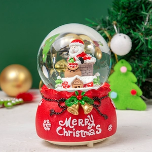 Detail of Christmas snow globe with Santa in chimney on red Merry Christmas base