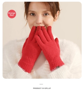Detail of orange red winter knit gloves featuring touchscreen fingertips and warm lining