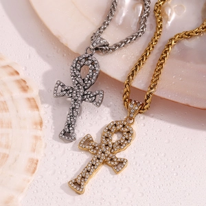 Close-up of gold and silver iced out Ankh cross pendants with Cuban link chains