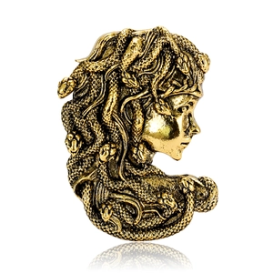 Vintage gold Medusa head brooch with detailed snake hair on a clean white background
