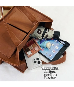 Top view of spacious brown PU leather tote bag with internal compartments and daily items