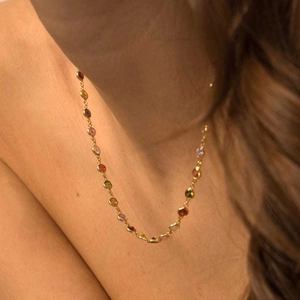 Close-up of 18K gold plated necklace with colorful round zircon stones on model neck