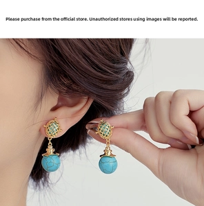 Detail of bohemian gold cage earrings with turquoise beads worn by a model