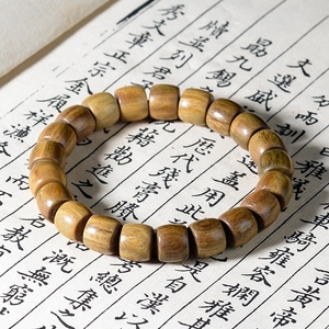 Ethno-Armband aus grünem Sandelholz mit Pflaumenanhänger auf Kalligraphie-Schriftrolle