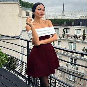 Elegant off-shoulder contrast dress featuring a white pleated top and burgundy A-line skirt