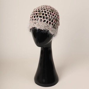 Détail du bonnet tissé main avec paillettes métalliques et franges sur mannequin noir