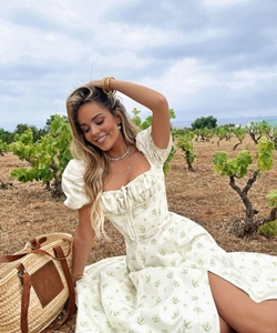 Detail of floral puff sleeve maxi dress with side slit in a sunny vineyard setting