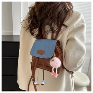 Vista posteriore dettagliata di un mini zaino a secchiello in denim con base in pelle marrone