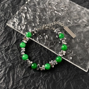 Detailed close-up of cat eye stone beads and polished steel tags on a beaded bracelet