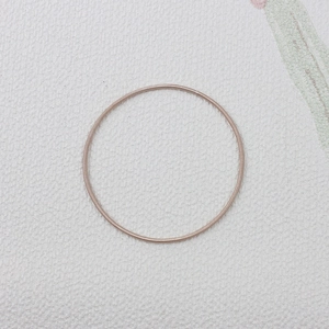 Macro shot of rose gold spring steel wire bracelet with spiral minimalist metal texture