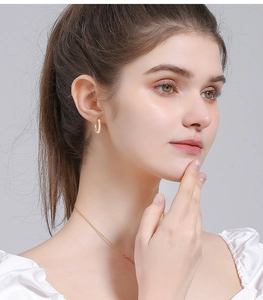 Close-up model view of small gold hoop earrings with micro-pave white cubic zirconia stones