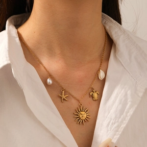 Gold plated stainless steel necklace with starfish turtle and sun charms on a model
