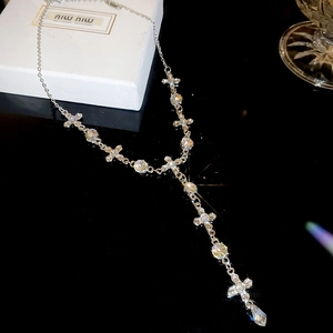 Detail view of silver cross and crystal drop necklace with sparkling rhinestone accents