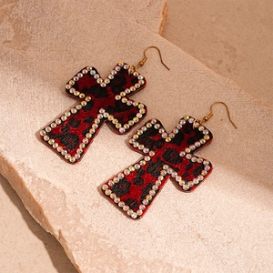Detail of cross earrings with leopard print flocking and sparkling rhinestone border