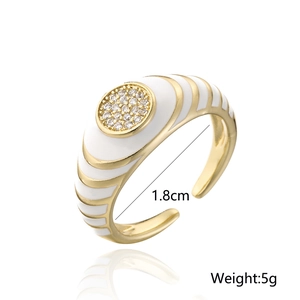 Detail view of gold geometric ring with white enamel and sparkling zircon accents