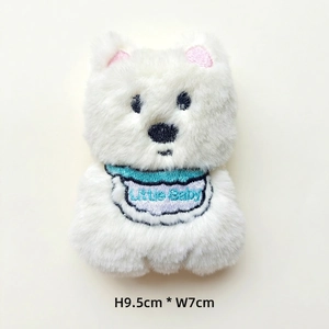 Detail of a 9.5cm white plush puppy charm with Little Baby embroidery and blue bib