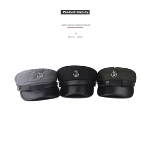Three nautical captain hats in grey black and green with metal anchor logos and leather brims