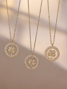 Gros plan de trois colliers trèfle plaqués or 18 carats avec pendentif en zircon brillant