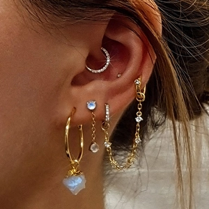 Macro view of gold S925 sterling silver ear cuff and long chain earring set with crystals