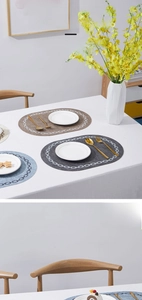 Close-up of leather placemat featuring elegant white chain pattern and modern teardrop shape