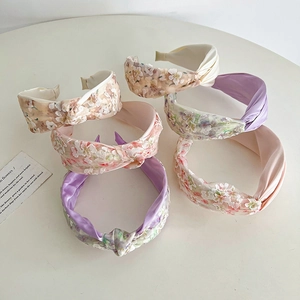 Detailed view of six floral lace embroidered knotted headbands in assorted pastel colors