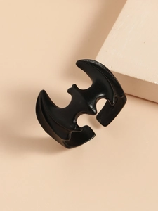Macro detail of gothic matte black bat wing ring on elegant minimalist stone background