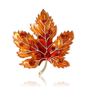 Luxurious maple leaf brooch with orange enamel and sparkling crystals on gold metal