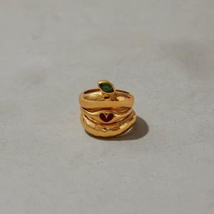 Three-piece gold plated ring set featuring green marquise gem, heart detail and hammered band