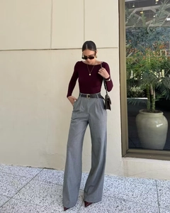 Detail of high-waisted gray striped wide-leg trousers with a slim burgundy off-shoulder top