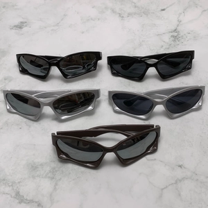 Futuristic Y2K sunglasses in silver, black and brown displayed on white marble surface