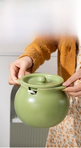 Ceramic lard jar detail showing heat-resistant double handles and green lid with spoon