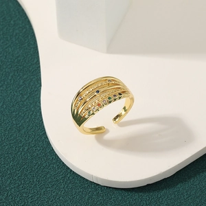 Modern gold-plated layered open ring with colorful zircon stones on white geometric stand