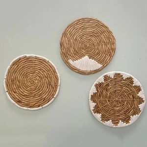 Dettagli di tre decorazioni murali in paglia intrecciata con motivi geometrici bianchi