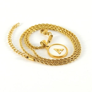 Detail of a gold stainless steel twist chain necklace with round letter A pendant