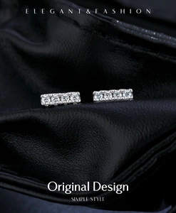 Macro de boucles d'oreilles en argent S925 avec pierres de moissanite sur cuir noir texture