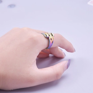 Macro shot of an adjustable rainbow stainless steel ring with a fluid streamlined design